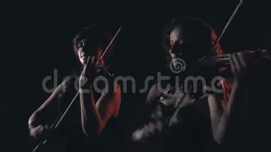 两位女小提琴手表演她们的角色。私密照明。